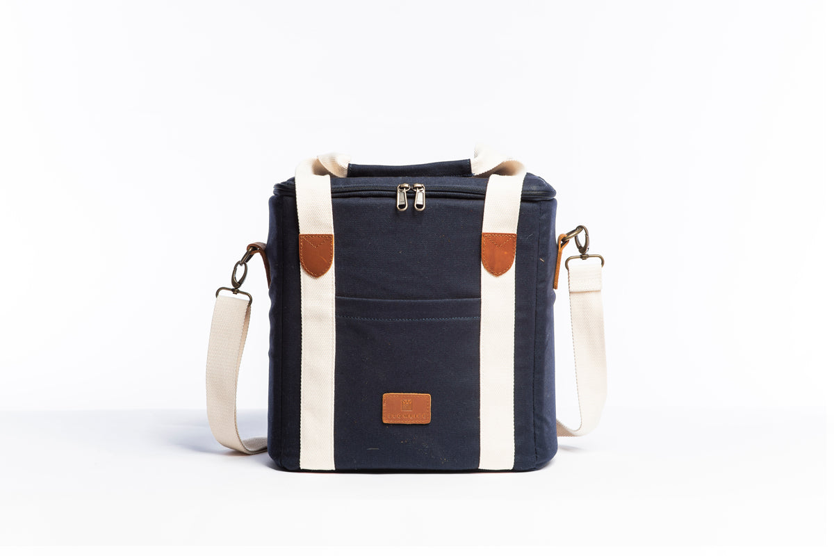 Front on image of the Slowlife Collection Navy Cooler Bag. This has a front pocket, leather detailing and a long shoulder strap included.