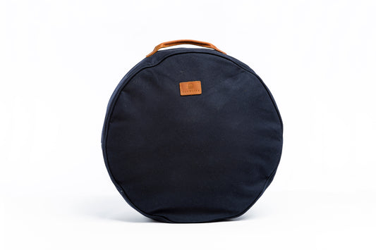 A front on photo of the Navy Slowlife Collection cushion. Showing the leather handle and branded patch.