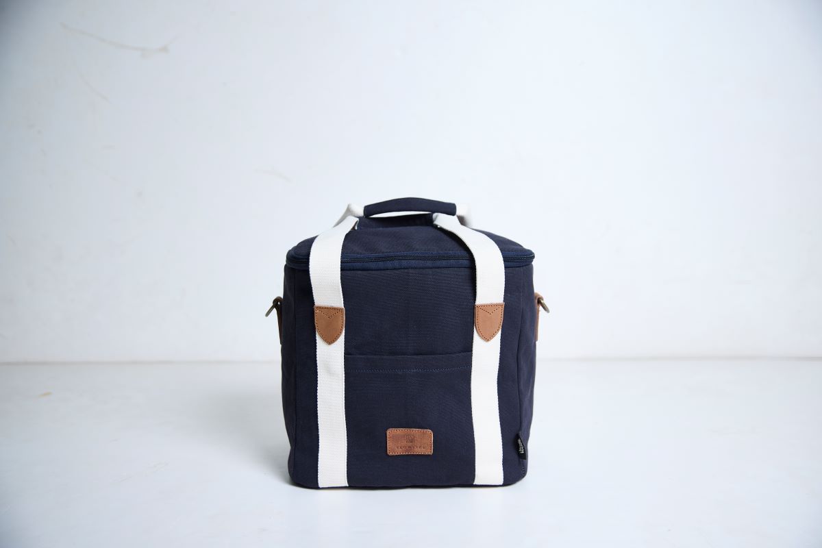 Navy blue cooler bag with white straps on a light gray background