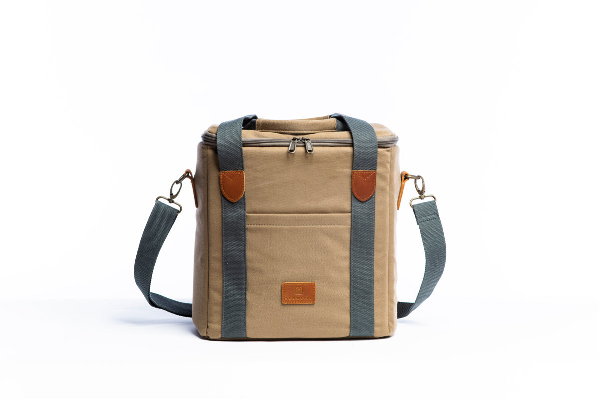 Front on image of the Slowlife Collection Olive Cooler Bag. This has a front pocket, leather detailing and a long shoulder strap included.