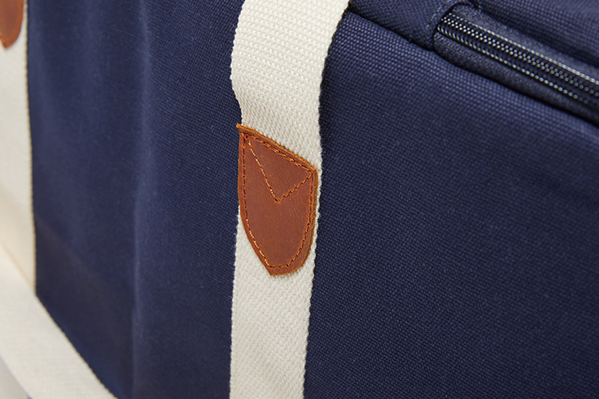 A close up image of the leather strap detailing on the Slowlife Collection Navy Picnic Bag.