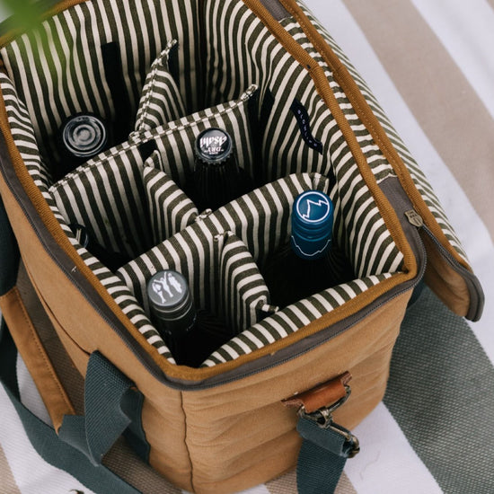 Brown cooler bag with striped interior holding bottles.