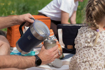 Person pouring from a blue insulated mug 