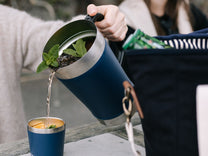 Cocktail poured into a Slowlife navy tumbler.