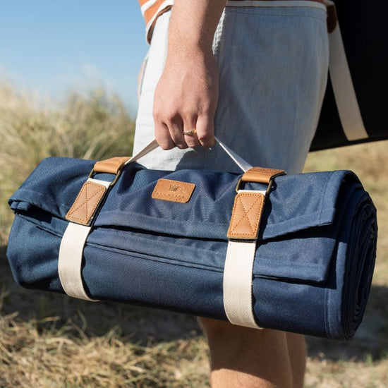  rolled-up blue picnic mat with leather straps