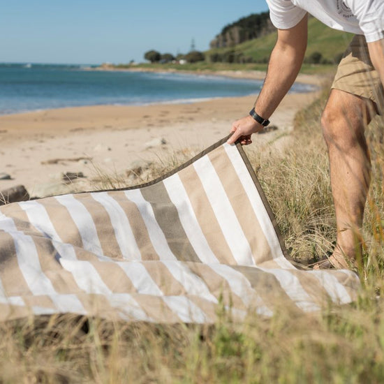  striped beach towel on sandy beach