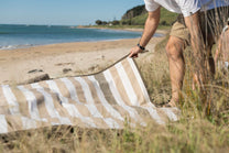  striped beach towel on sandy beach