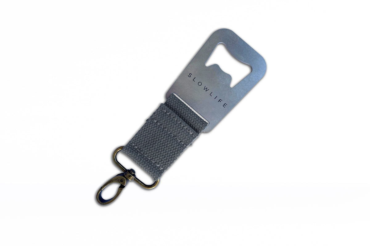 Grey Slowlife Collection bottle opener with click attached to one end