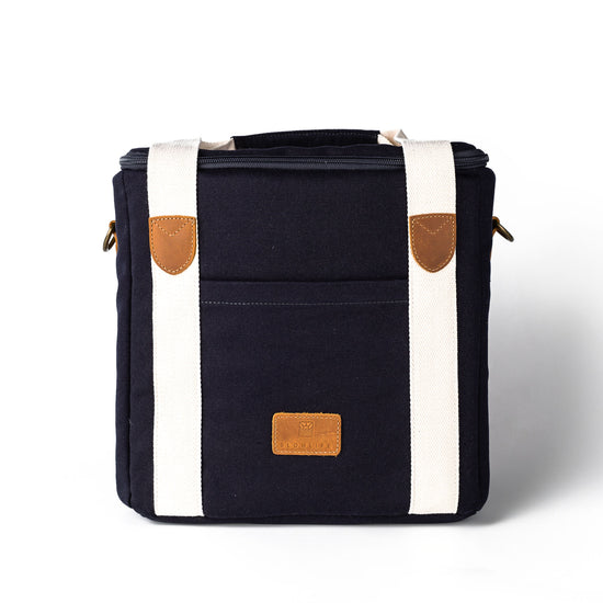 Black bag with white accents and brown leather patches 