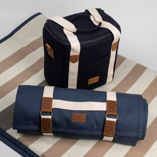 Navy blue bag with brown straps on a striped fabric