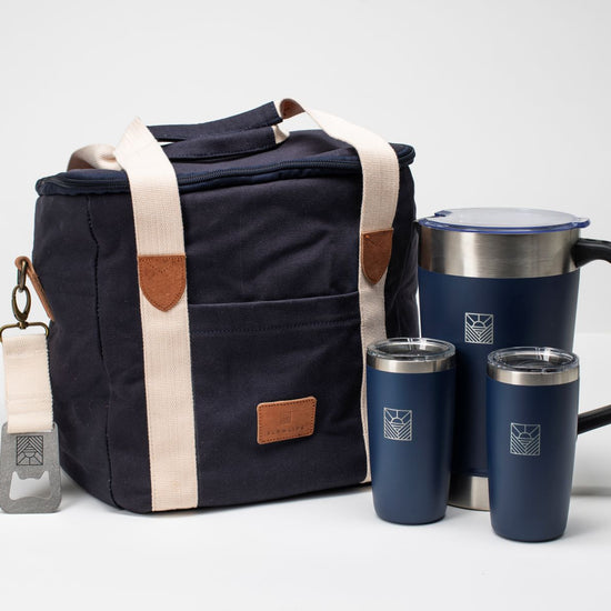 Navy blue bag with beige accents and a matching travel mug and tumblers 