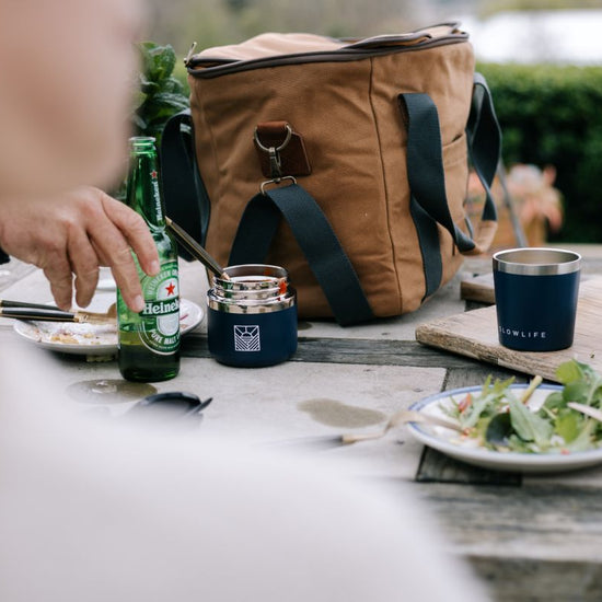 Person opening bottle at picnic table