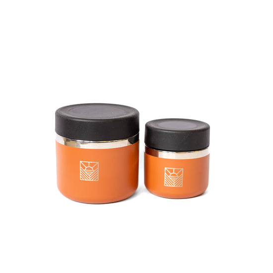 Two orange jars with black lids 